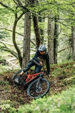 Abus MoDrop MTB Helm - Zwart -Gelukkig Sporten modrop mtb sfeerfoto fietsende vrouw bos